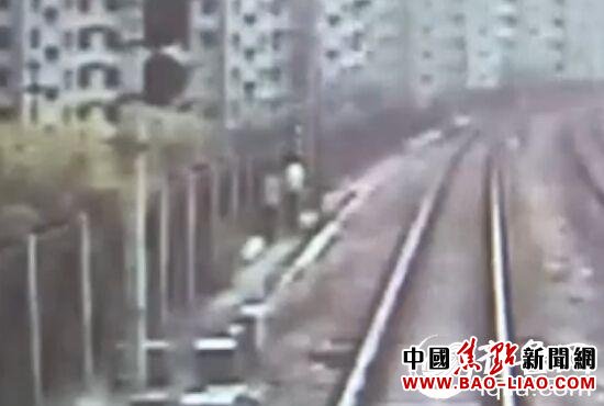 火车行车记录仪拍摄下的画面显示,当火车将要行至德州站操车场时,前方百余米处的铁轨附近,有一对青年男女正迎着夏日的阳光在铁轨上悠闲地牵手散步。(视频截图)
